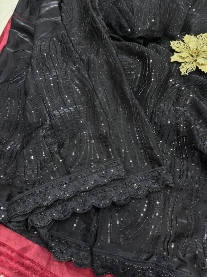 The saree in the image is crafted from sequin-embroidered net or organza fabric, layered over a smooth satin or silk-blend inner petticoat and blouse.
